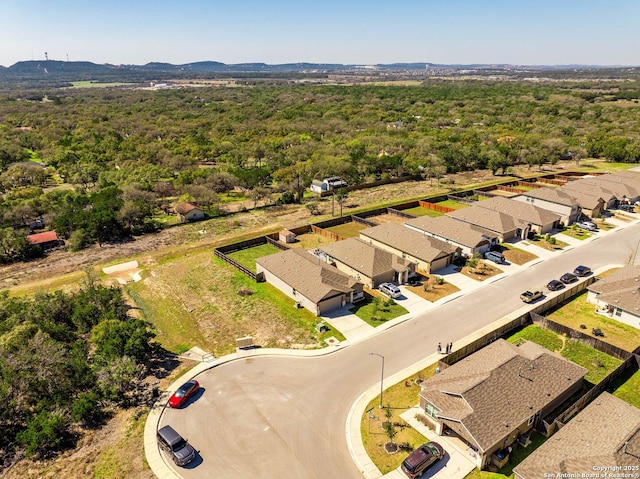 bird's eye view with a wooded view, a mountain view, and a residential view