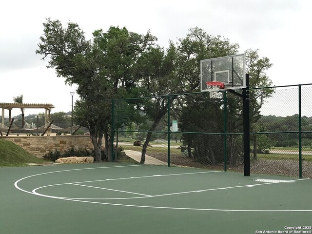 view of basketball court with community basketball court and fence