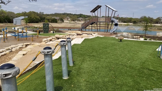 communal playground featuring a yard and a water view