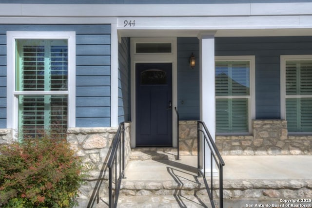 entrance to property with stone siding and covered porch