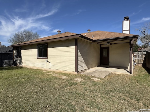 back of property featuring a ceiling fan, fence, a yard, a chimney, and a patio area