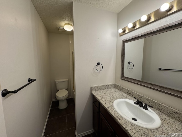 bathroom featuring vanity, tile patterned floors, toilet, and a textured ceiling