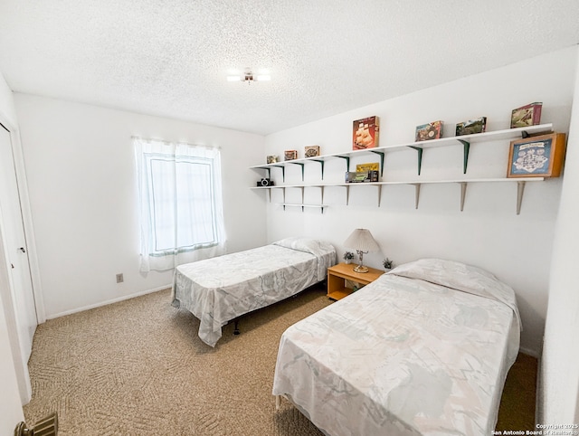 bedroom with baseboards, carpet floors, and a textured ceiling