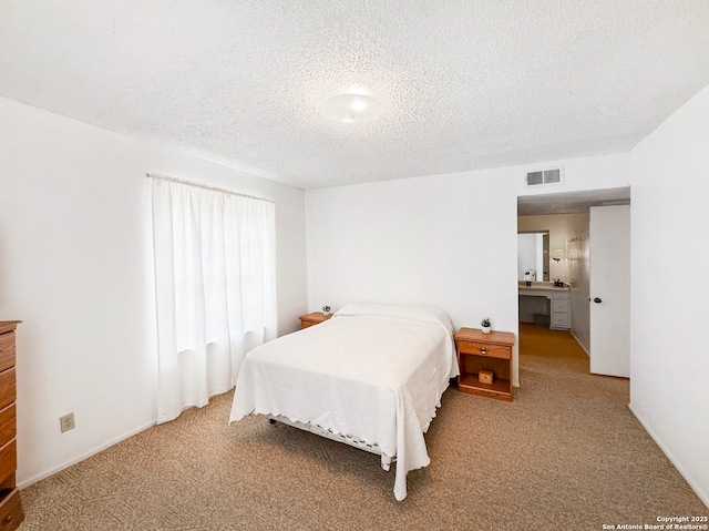 carpeted bedroom featuring visible vents and a textured ceiling