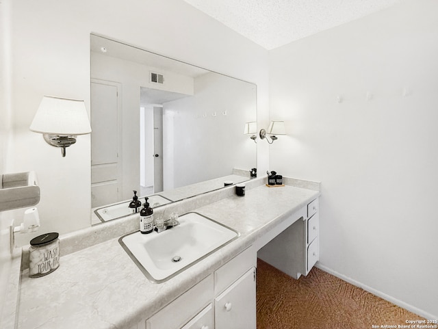 bathroom with vanity, baseboards, visible vents, and a textured ceiling