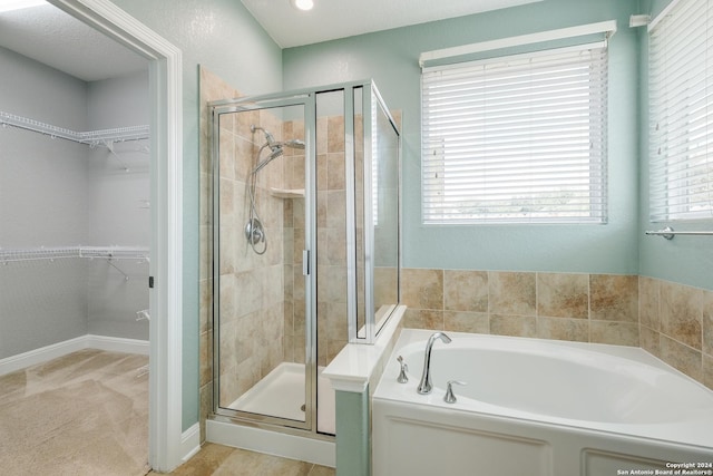 12535 Quarter J, San Antonio, TX 78254 - full bath with a walk in closet, baseboards, a garden tub, and a stall shower