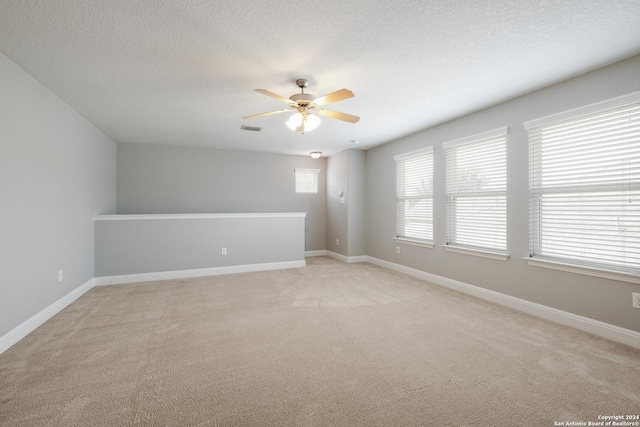 12535 Quarter J, San Antonio, TX 78254 - spare room with visible vents, light carpet, a ceiling fan, a textured ceiling, and baseboards