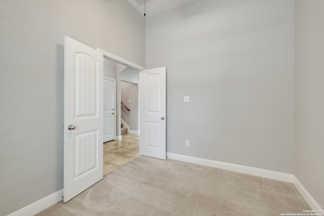 12535 Quarter J, San Antonio, TX 78254 - empty room with a high ceiling, baseboards, light colored carpet, and attic access