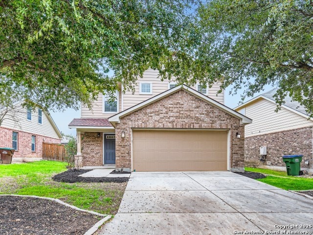 traditional-style home featuring brick siding, fence, concrete driveway, a front yard, and a garage