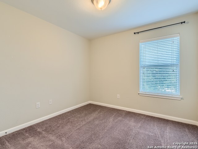 carpeted spare room featuring baseboards