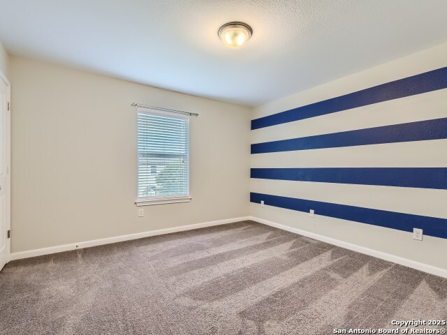 carpeted empty room with baseboards