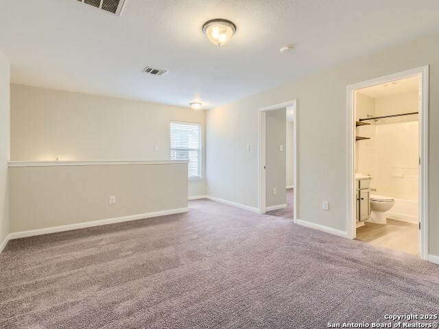 carpeted spare room with baseboards and visible vents