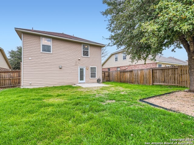 back of house featuring a patio area, a lawn, and a fenced backyard