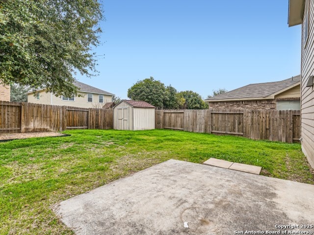 view of yard with a fenced backyard, a storage unit, an outdoor structure, and a patio