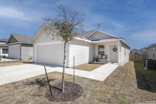 view of front facade featuring fence, central AC unit, concrete driveway, a front lawn, and a garage