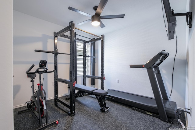 workout room featuring baseboards and ceiling fan