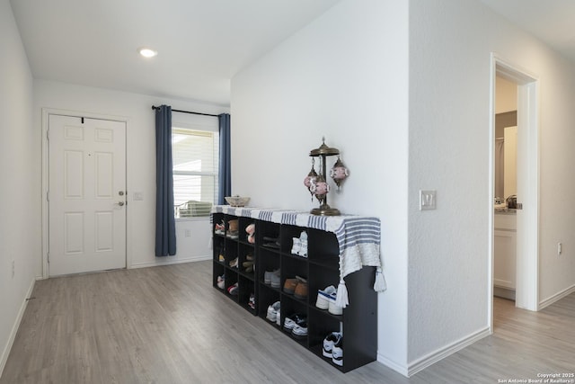 foyer entrance with baseboards and wood finished floors