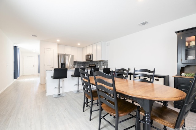 dining space with recessed lighting, visible vents, light wood-style flooring, and baseboards