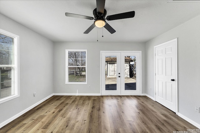 spare room with ceiling fan, french doors, baseboards, and wood finished floors