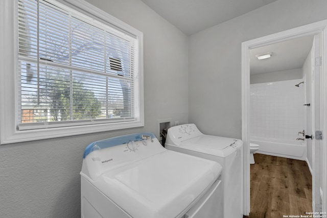 laundry area with laundry area, wood finished floors, and washer and clothes dryer