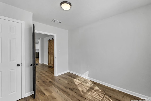 empty room with visible vents, baseboards, and wood finished floors