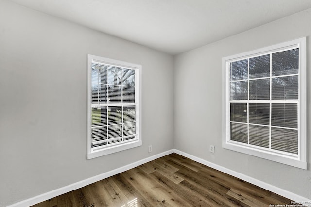 unfurnished room featuring dark wood finished floors and baseboards