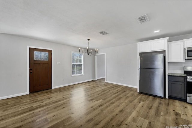 kitchen with visible vents, a notable chandelier, appliances with stainless steel finishes, and wood finished floors