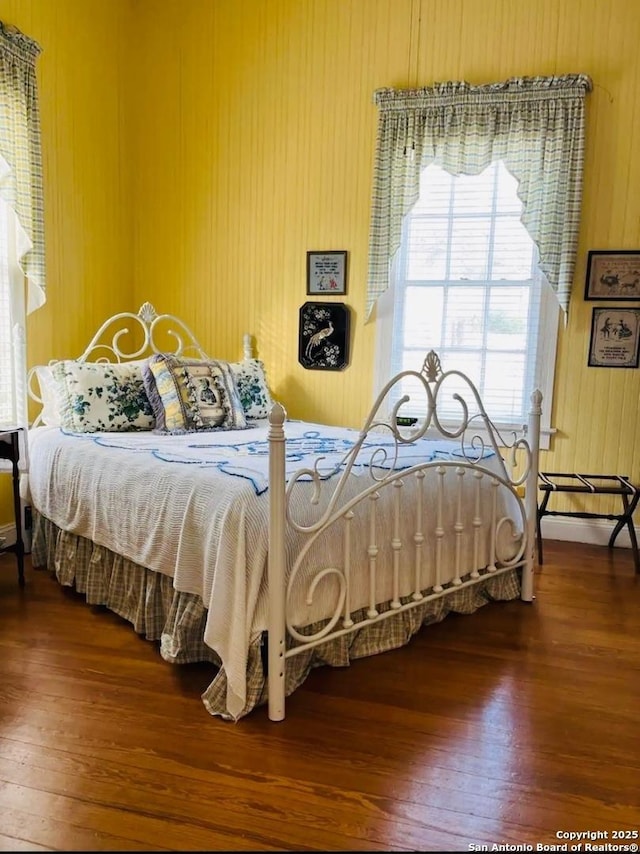 bedroom featuring wooden walls and wood finished floors