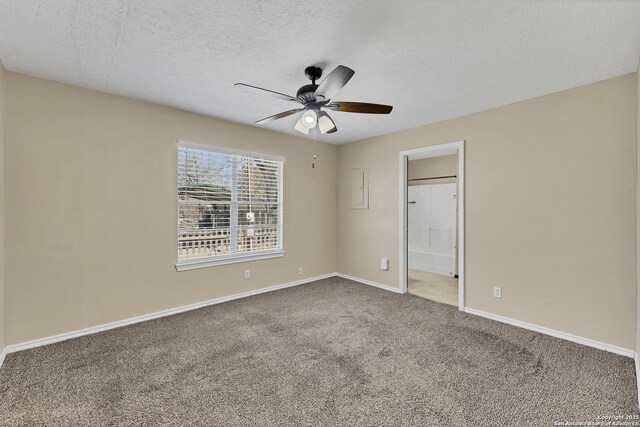 unfurnished bedroom with a ceiling fan, carpet, baseboards, ensuite bathroom, and a textured ceiling