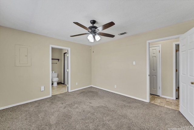 unfurnished bedroom featuring electric panel, carpet flooring, a textured ceiling, and visible vents