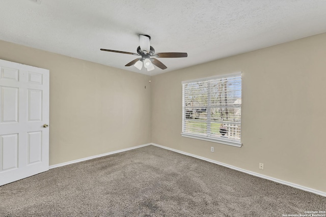 carpeted spare room featuring a ceiling fan, baseboards, and a textured ceiling