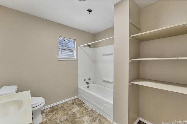 full bathroom featuring toilet, stone finish flooring,  shower combination, baseboards, and vanity