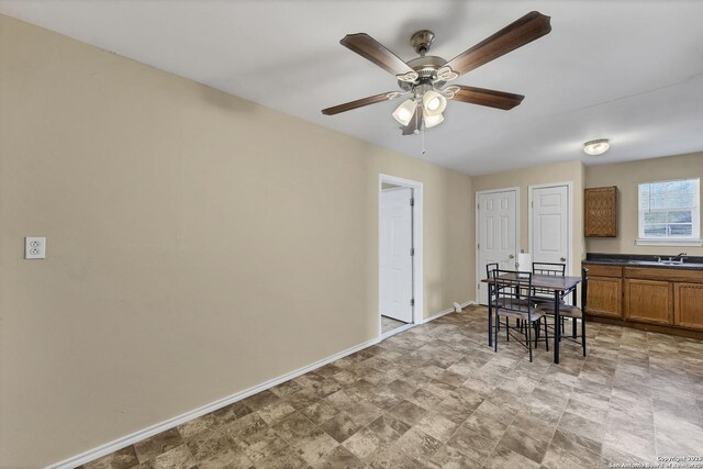 dining space featuring a ceiling fan and baseboards