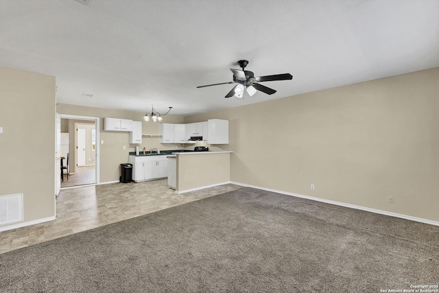 unfurnished living room with visible vents, light colored carpet, ceiling fan with notable chandelier, and baseboards