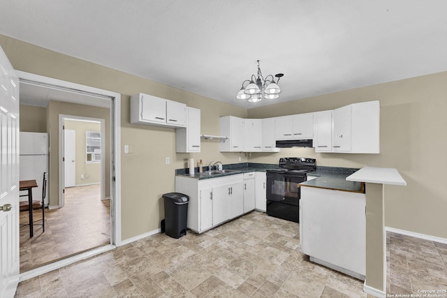 kitchen with a sink, dark countertops, freestanding refrigerator, black / electric stove, and a chandelier