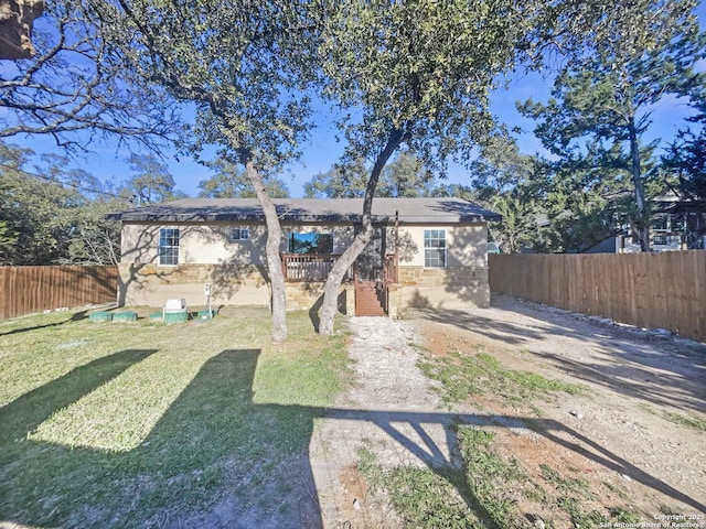 rear view of house with a yard, fence private yard, and stucco siding