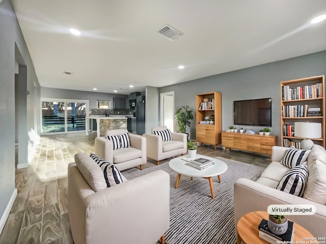 living room featuring recessed lighting, visible vents, and light wood-style floors