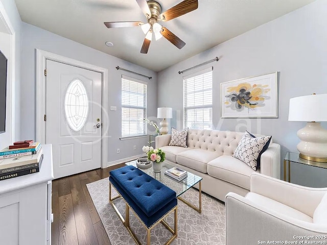 living area featuring ceiling fan, baseboards, and dark wood finished floors