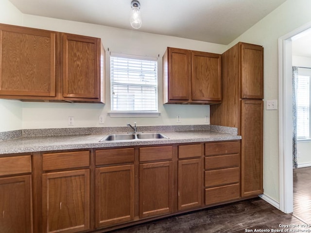 kitchen with a sink, brown cabinets, and dark wood finished floors