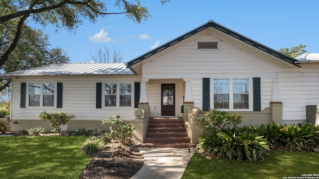 view of front of property featuring metal roof, a standing seam roof, and a front yard