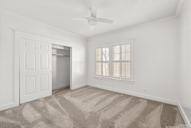 unfurnished bedroom featuring baseboards, carpet floors, ceiling fan, a closet, and crown molding