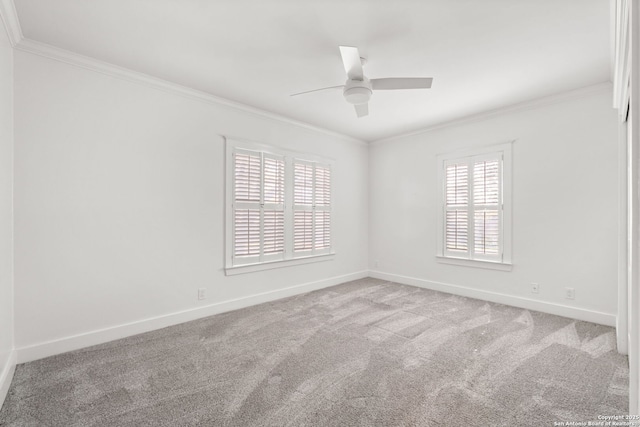 carpeted empty room featuring crown molding, baseboards, and ceiling fan