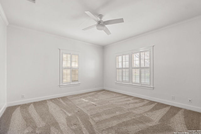 carpeted empty room with baseboards, a ceiling fan, and crown molding