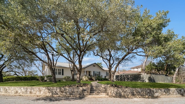 single story home with a front lawn and fence