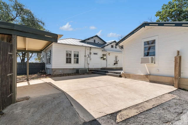 back of property with a patio, fence, a standing seam roof, entry steps, and metal roof