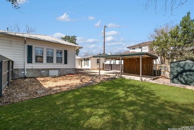 view of yard with a patio, a storage shed, an outdoor structure, and fence