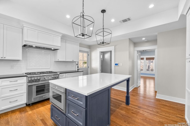 kitchen with white cabinetry, backsplash, a chandelier, and stainless steel appliances