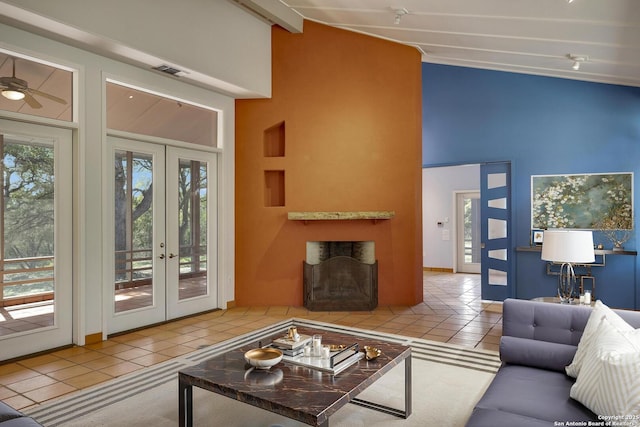 tiled living room with beam ceiling, french doors, visible vents, and high vaulted ceiling