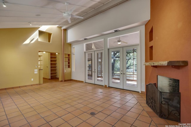 interior space with a fireplace, vaulted ceiling with beams, a ceiling fan, and french doors