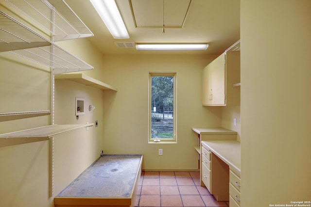 laundry room featuring visible vents, attic access, light tile patterned floors, hookup for a washing machine, and cabinet space